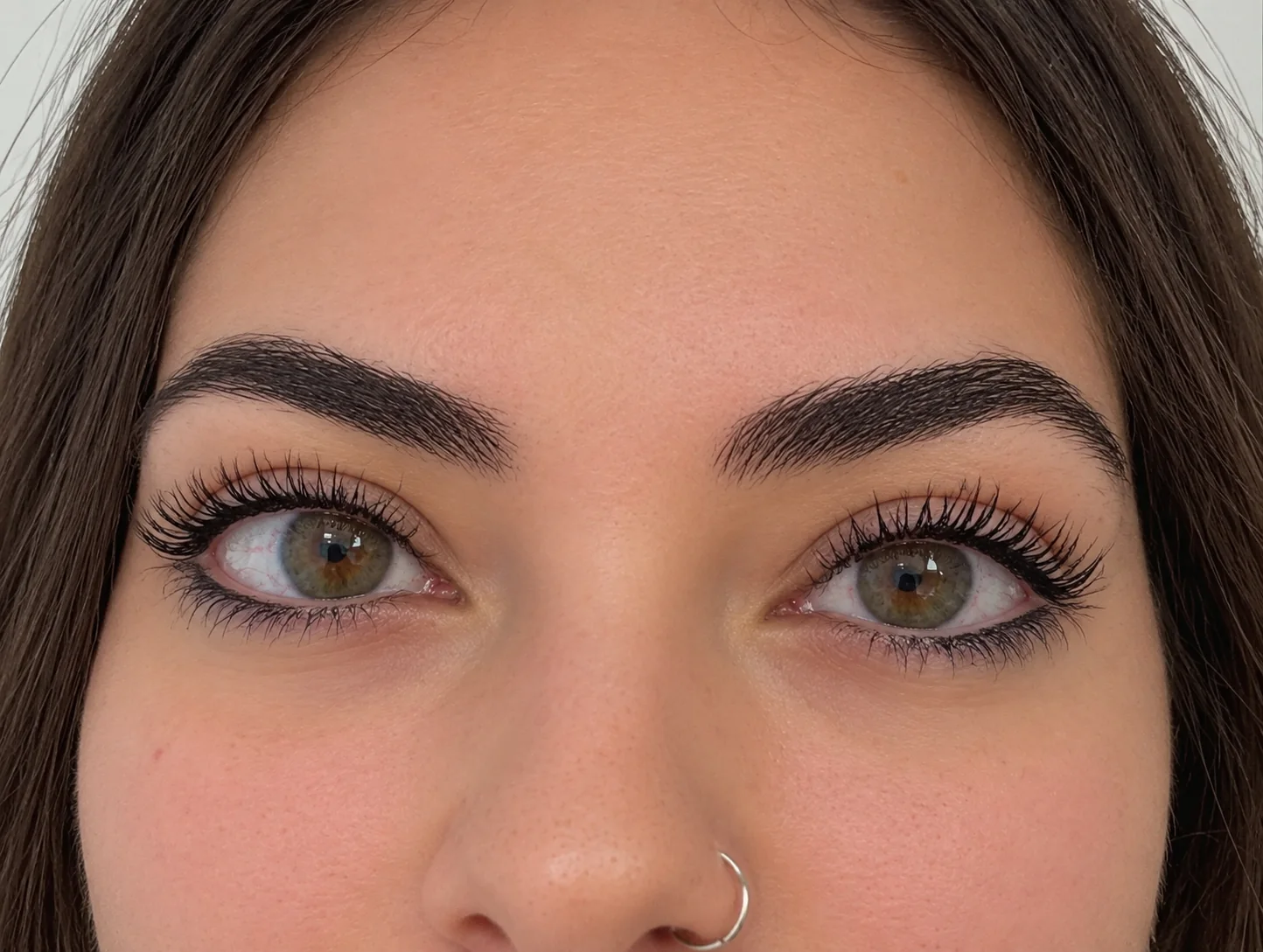 Sopracciglia ed eyeliner col trucco semipermanente, occhi aperti